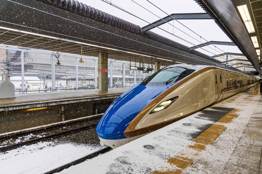 bullet train pulling into station in the snow