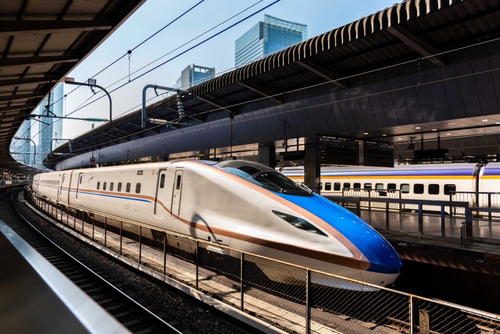 bullet train pulling into a station in japan. bus + bullet train packages